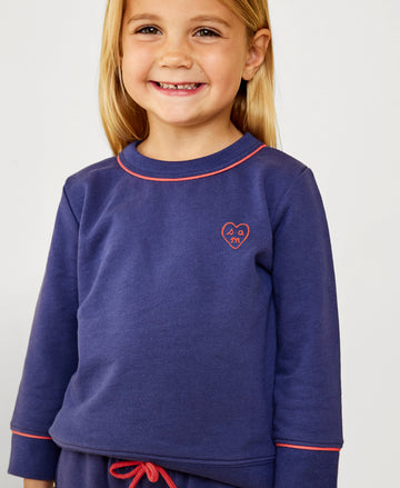 Girl smiling at camera in sweatshirt in studio shoot